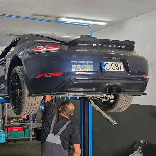Mechanik naprawiający samochód Porsche w warsztacie Premium Service